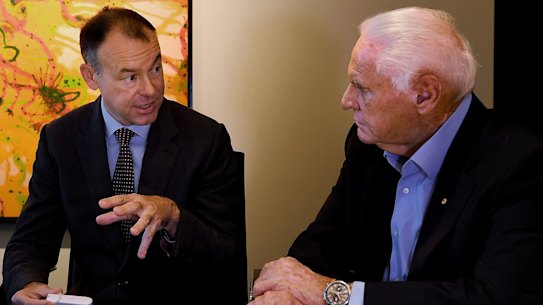 Atomo Diagnostics co-founder John Kelly (left) shows investor Lang Walker the self-testing HIV blood kit, which might also be used for testing COVID-19. 