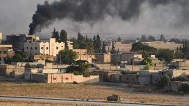 A Turkish army armoured vehicle advances in the Syrian city of Tel Abyad, as seen from the Turkish border town of Akcakale on October 13.