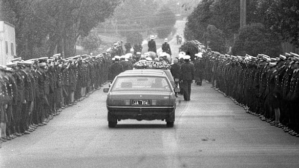 A police guard lines View Mount Road as the cortege leaves for Springvale cemetery.