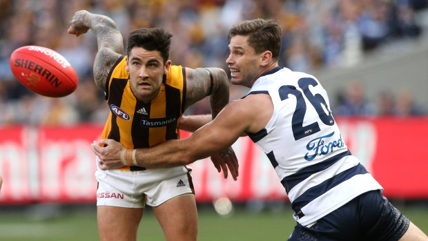 Grab and go: Hawthorn's Chad Wingard 
attempts to break a tackle by Geelong forward Tom Hawkins.