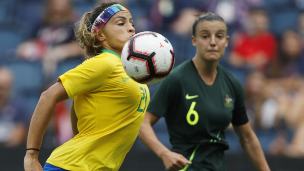 Brazil defender Monica controls the ball as Australia's Chloe Logarzo closes in.