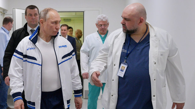 Russian President Vladimir Putin and the Kommunarka hospital's chief Denis Protsenko, right, walk in to the hospital for coronavirus patients on March 23.
