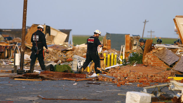 Workers look through tornado damage at the American Budget Value Inn in El Reno.