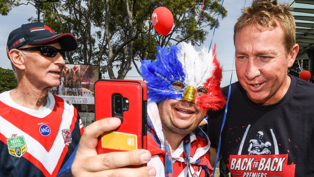 Roosters coach Trent Robinson poses for a selfie with a fan.