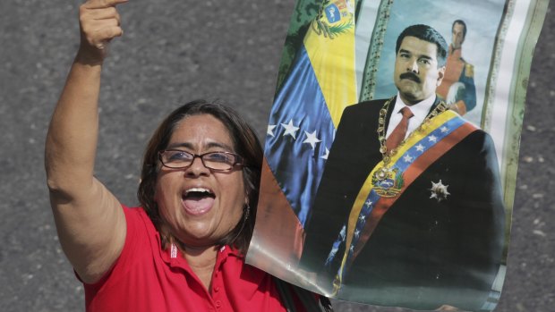 A supporter of Venezuelan President Nicolas Maduro holds a poster of him during a rally in Caracas on Labour Day.