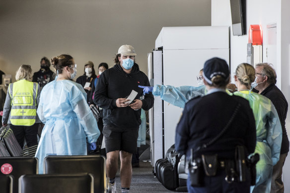 Passengers on a Jetstar flight from Melbourne are screened by NSW Health as they exit the aircraft at Sydney Airport.