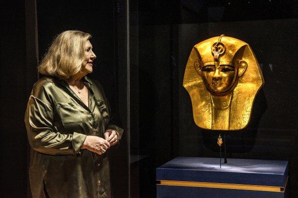 Kim McKay with the gilded mask from the coffin of Amenempe, part of the Rameses exhibition at The Australian Museum.
