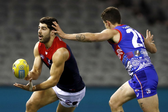 Christian Petracca handballs for Melbourne against the Bulldogs on Friday night.
