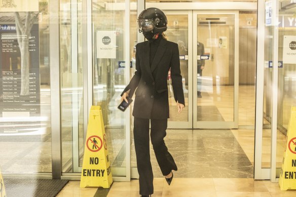 Gemma Wright, the partner of surgeon William Mooney, leaves the hearing  wearing a motorcycle helmet. 