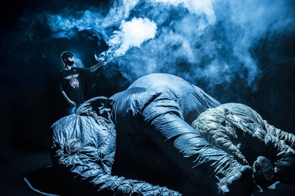 Tour guide Jimmy Hodgson, 14, holds a smoke machine over giant inflatable elephants. 