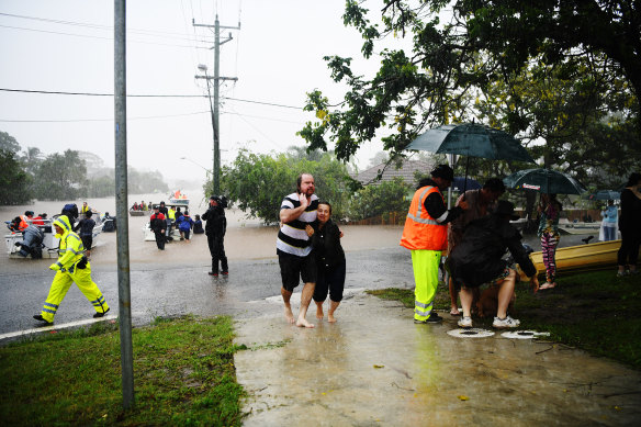 Survivors reach dry land after floods inundated homes in Lismore on February 28, 2022.