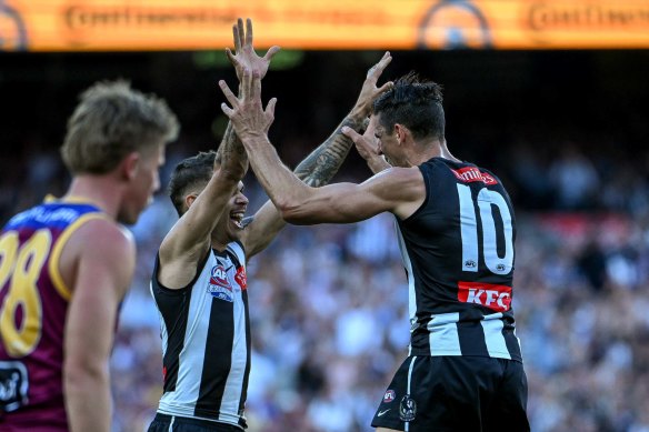 Bobby Hill and Scott Pendlebury celebrate a goal during the game.