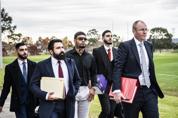 Taylan May (centre) walks into the board meeting flanked by his legal team on Tuesday