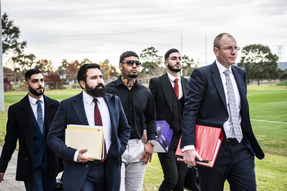 Taylan May (centre) walks into the board meeting flanked by his legal team earlier this month.