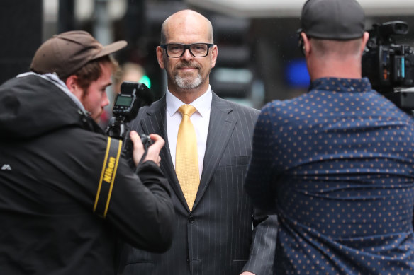 Former police commissioner Simon Overland (centre) in 2019.