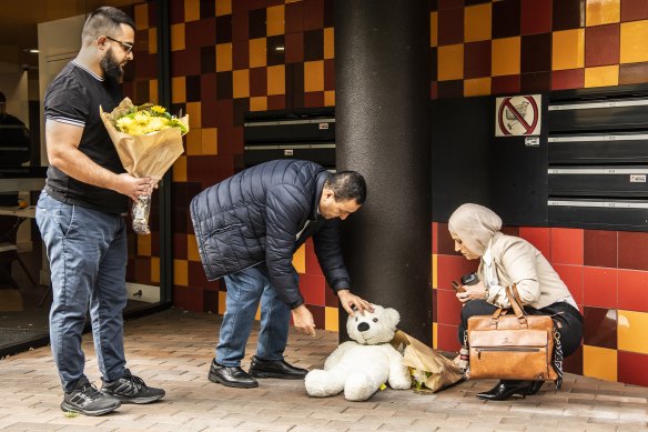 Counsellors from a nearby community centre leave a bear and flowers at the unit complex in Riverwood.