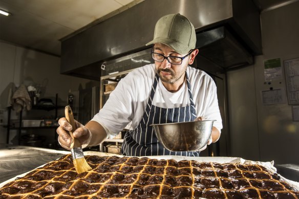 Max Luison from Nonie’s food in Botany glazing hot cross buns. 