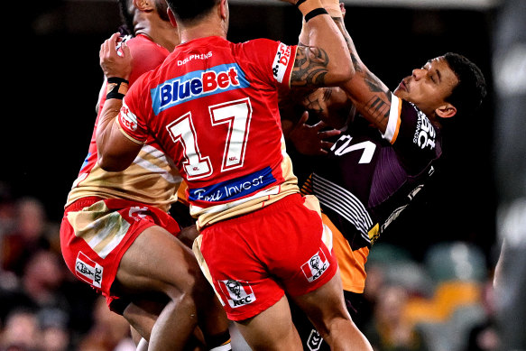 Tristan Sailor of the Broncos and Hamiso Tabuai-Fidow of the Dolphins compete for the ball during the Battle of Brisbane at the Gabba in July.