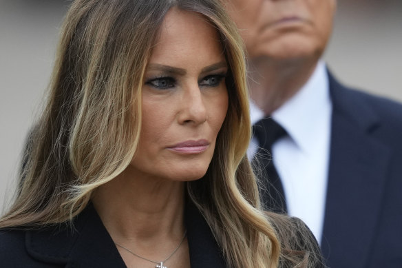 Former president Donald Trump stands behind his wife Melania as she watches pallbearers carry the coffin of her mother, Amalija Knavs.