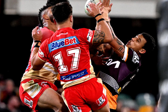 Tristan Sailor of the Broncos and Hamiso Tabuai-Fidow of the Dolphins compete for the ball during the Battle of Brisbane at the Gabba in July.
