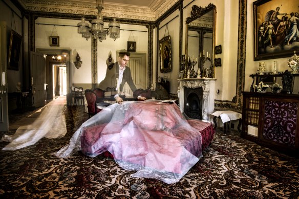 Adam Lindsay, executive director of Sydney Living Museums uncovering furniture which has been protected from dust and sunlight in the drawing room of Vaucluse House. 