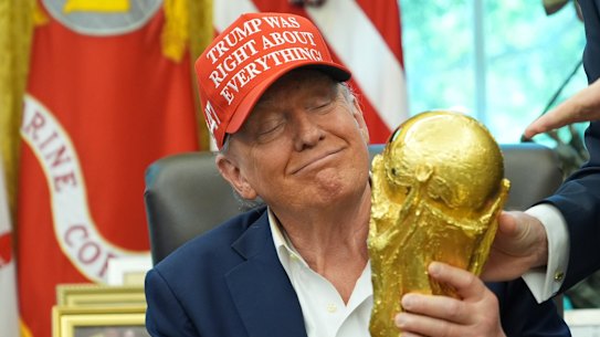 President Donald Trump holds the FIFA World Cup Winners Trophy during an announcement in the Oval Office of the White House on Friday.