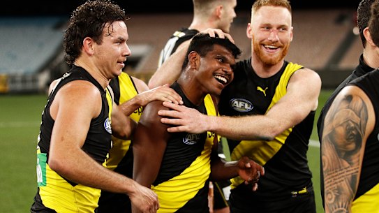 Maurice Rioli jnr celebrates victory with Nick Vlastuin and their Tigers teammates, including Daniel Rioli (left).