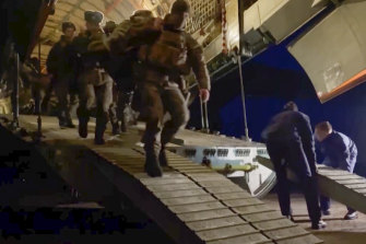 In this image taken from footage provided by the RU-RTR Russian television, Russian peacekeepers exit a Russian military plane in an airport in Kazakhstan, Thursday, January 6, 2022.