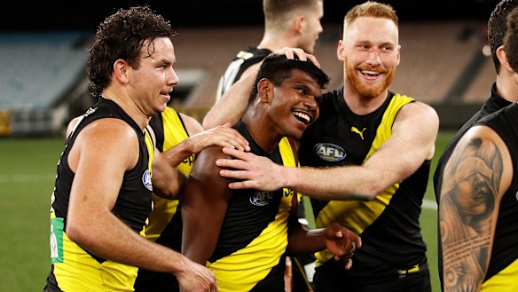 Maurice Rioli jnr celebrates victory with Nick Vlastuin and their Tigers teammates, including Daniel Rioli (left).