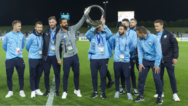 Night off: Sydney FC players show off their A-League championship trophy before the game on Tuesday night.