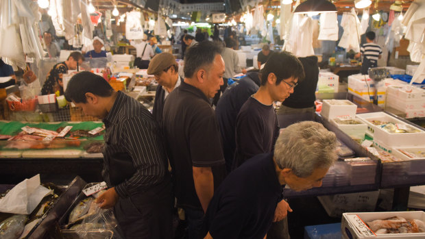 Wholesalers and customers walk through Tsukiji.  On its last day, few welcomed the prospect of an air-conditioned future. 