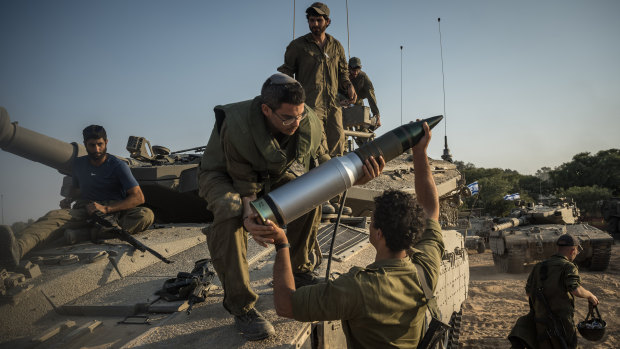 Israeli soldiers load tank shells as their unit massed in Be’eri, near the border with the Gaza Strip on Saturday.