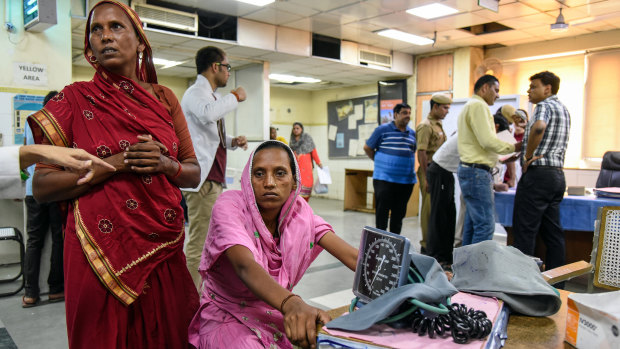 Rehmati, in pink, sits in the emergency ward of a New Delhi hospital where she arrived with symptoms of heat stroke last month.