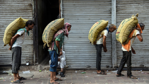 Workers carry sacks of spices on a hot summer morning in the old quarter of Delhi.