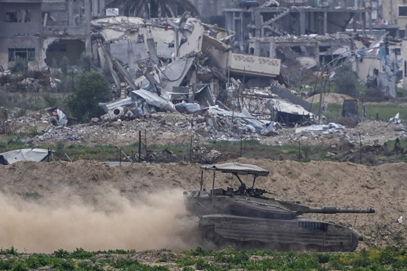 Israeli soldiers drive a tank inside the Gaza Strip, as seen from southern Israel.