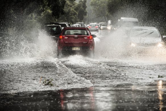 Cars drive along flooded roads in Five Dock on Tuesday. 