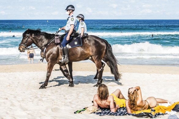 Police patrolled Bondi Beach as the government tightened restrictions on Saturday.