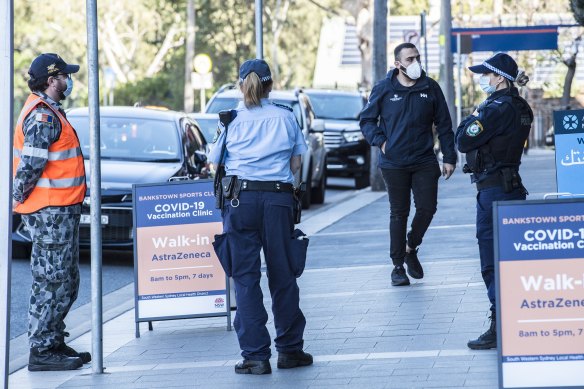 Police patrol outside a vaccination centre on a Bankstown shopping strip during the Delta lockdown in August 2021.
