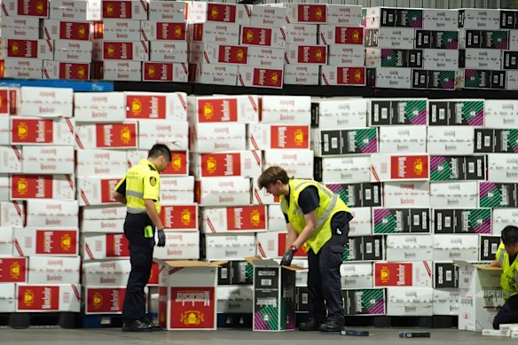 Australian Border Force officers check illegal cigarette imports found in shipping containers.