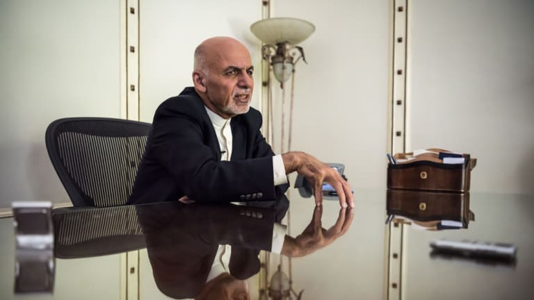 Afghan President Ashraf Ghani speaks on the phone with relatives of the Afghan soldier killed in battle, from his office in Kabul.