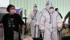 Air China flight crew members in hazmat suits walk through the arrivals area at Los Angeles International Airport on Tuesday (Wednesday AEDT). 