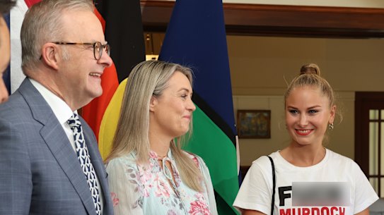 Grace Tame (right) greets Prime Minister Anthony Albanese and his fiancee Jodie Haydon at the Lodge while wearing a t-shirt emblazoned with the slogan “f— Murdoch”. 