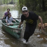 Alvaro Trevino pulls a canoe with Jennifer Tellez and Ailyn, 8, after they checked on their home after flooding in Spendora, Texas.
