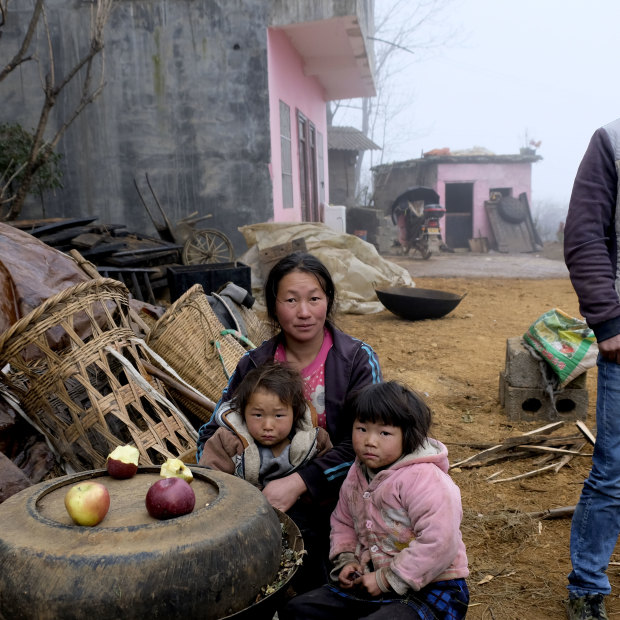 'It was a bitter experience': Xia Dayun, 33, with his wife Xu Xuanhua and their children outside the concrete house built with his earnings from migrant labour in Xinjiang.