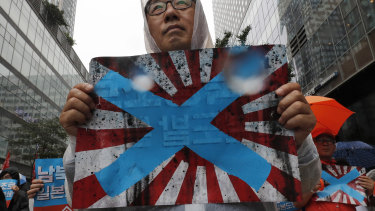 South Korean protesters in Seoul last month hold Japanese rising sun flags during a rally to mark South Korea's liberation from Japanese colonial rule.