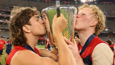 Luke Jackson and Clayton Oliver celebrate with the premiership cup.