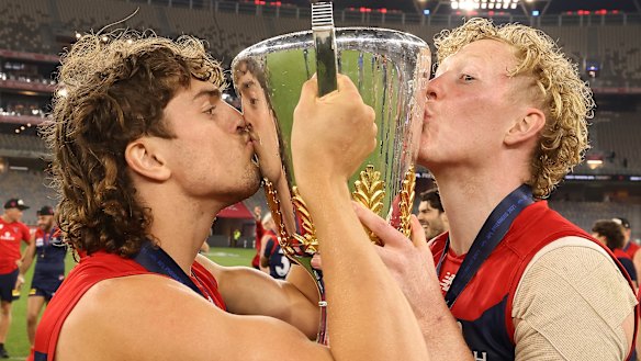Luke Jackson and Clayton Oliver celebrate with the premiership cup.