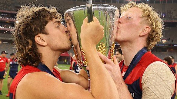 Luke Jackson and Clayton Oliver celebrate with the premiership cup.