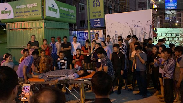 A woman is tended to after she was assaulted in a casino carpark in Sihanoukville, Cambodia.