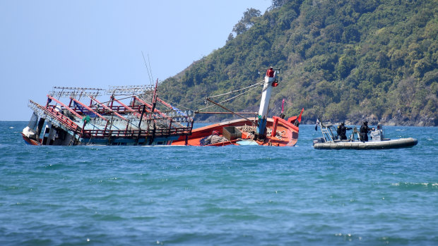 Police inspect a sunken fishing vessel, believed to be carrying Vietnamese asylum seekers, at Cape Kimberley at the mouth of the Daintree River in Queensland last year.